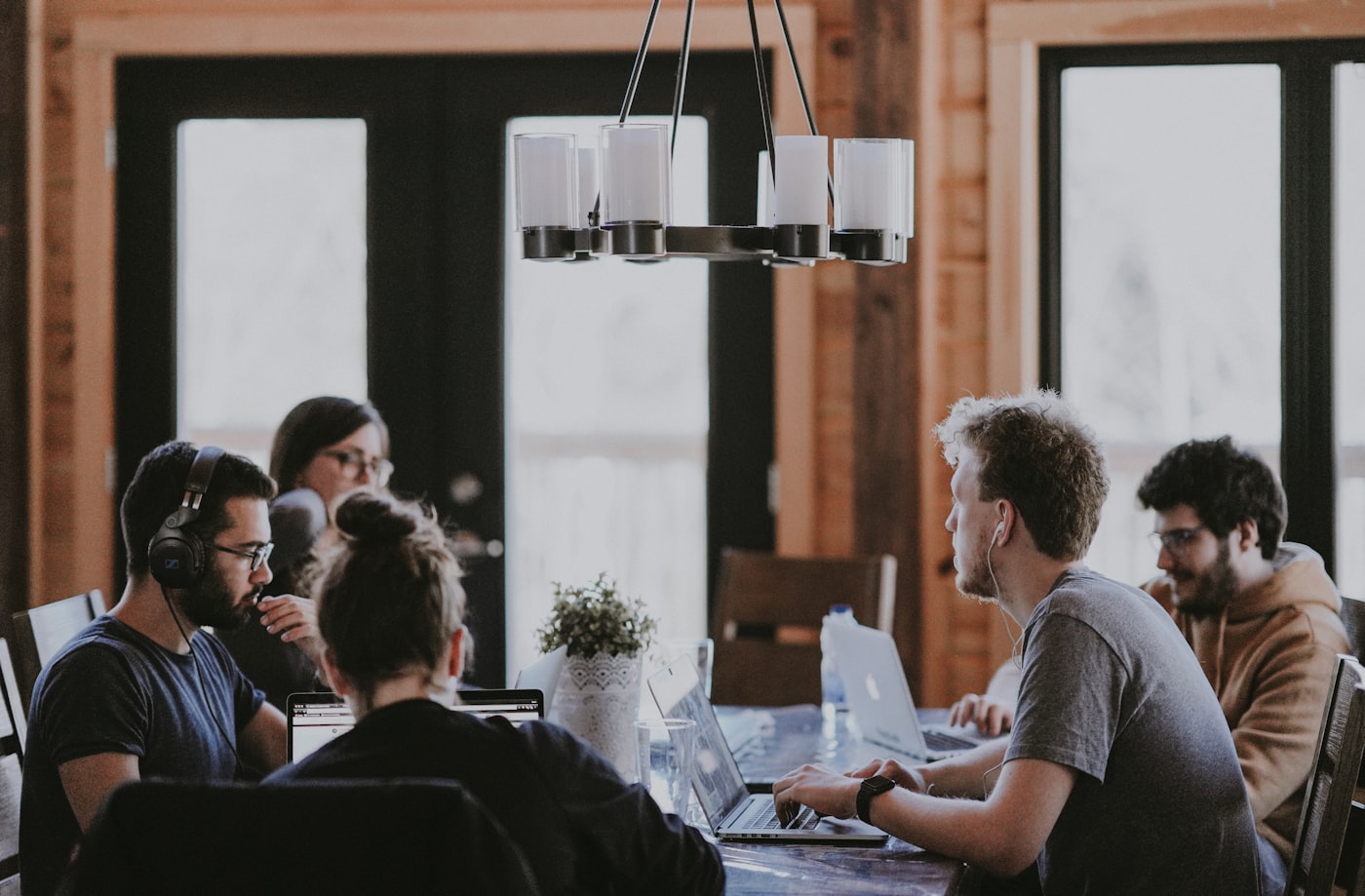 A team gathered around a table, working together — the everyday collaboration a workplace giving program plugs into.